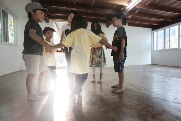 Grupo de pequeños niños asiáticos jugando juntos en casa, fondo del concepto de educador en casa