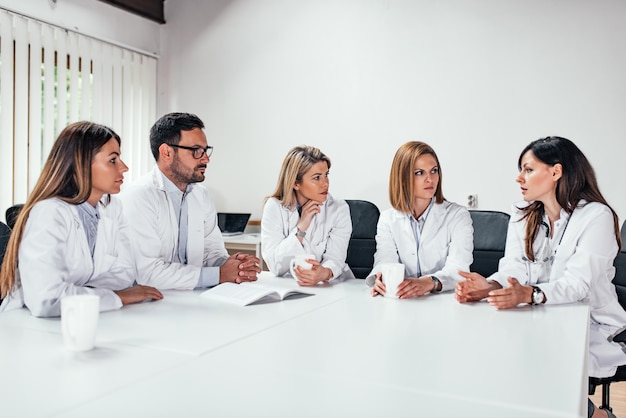 Grupo de personal médico hablando en una reunión.