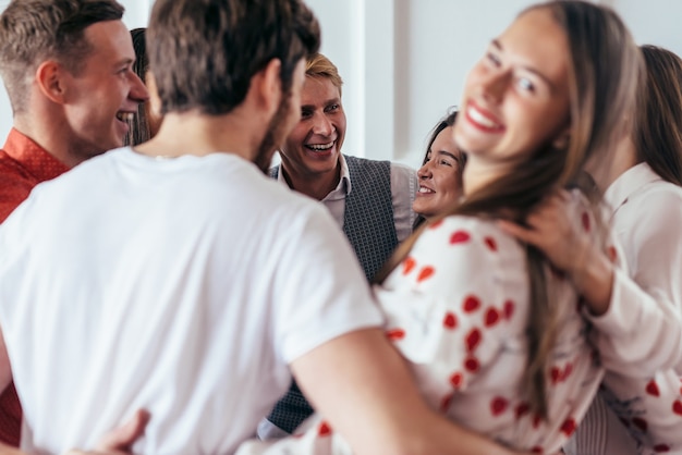 Grupo de personas abrazándose divirtiéndose juntos.