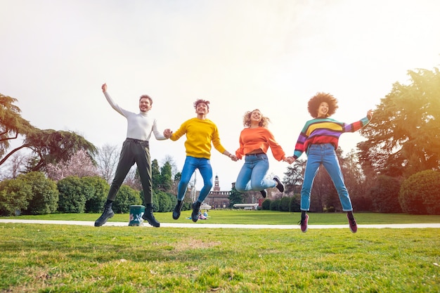 Foto grupo de personas amigos saltando la luz de fondo al aire libre