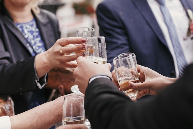 Grupo de personas animando y brindando con champán en la recepción de la boda Empresario corporativo tintineando con bebidas alcohólicas en una fiesta al aire libre Fiesta de Navidad de lujo