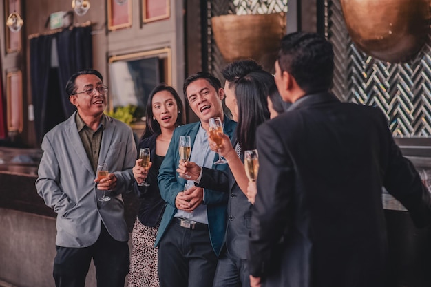 Grupo de personas asiáticas bebiendo en el equipo de negocios de felicitaciones de fiesta Grupo de amigos disfrutando de bebidas nocturnas en el bar