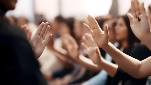 Un grupo de personas en un auditorio con las manos en alto