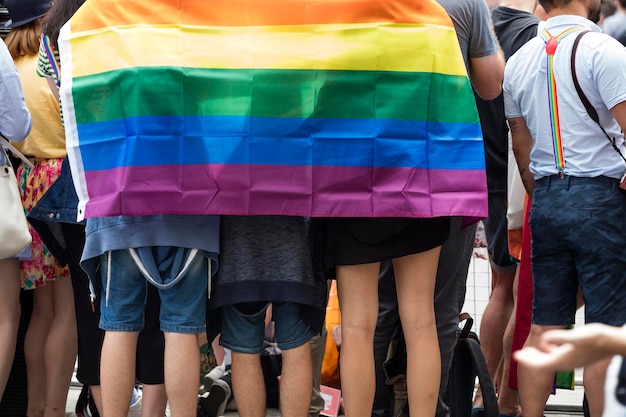 Foto grupo de personas con la bandera del arco iris gay en una marcha del orgullo gay lgbt en londres