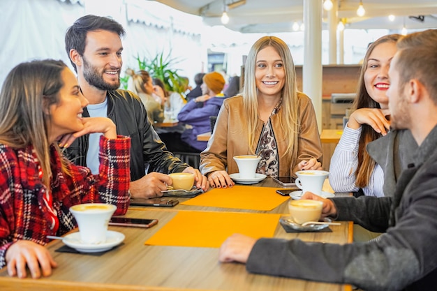 Grupo de personas bebiendo capuchino en un bar.