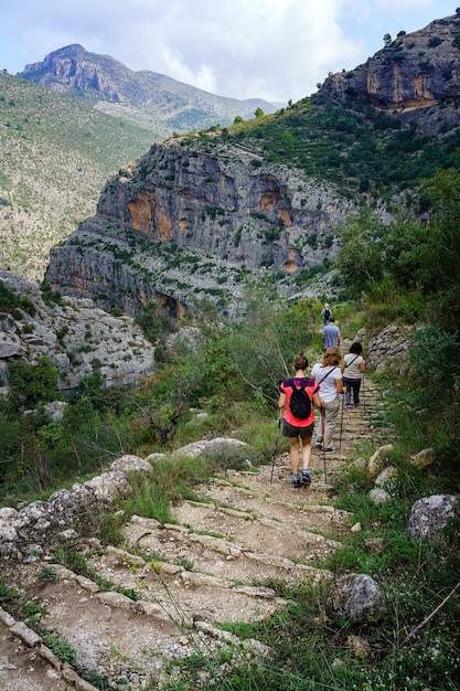 Grupo de personas caminando por el sendero de la montaña bajando escalones.