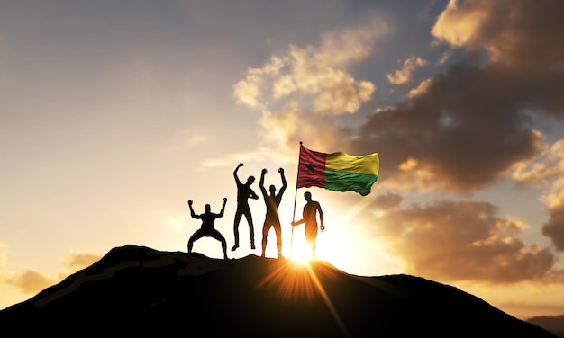 Un grupo de personas celebra en la cima de una montaña con la bandera de guinea bissau d render