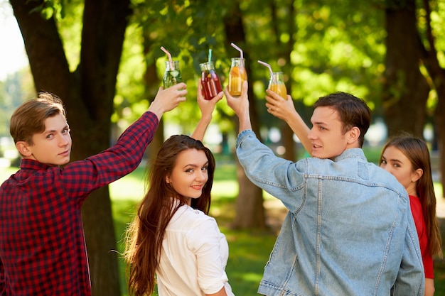 Grupo de personas celebran con cócteles de jugo de desintoxicación en naturaleza verde