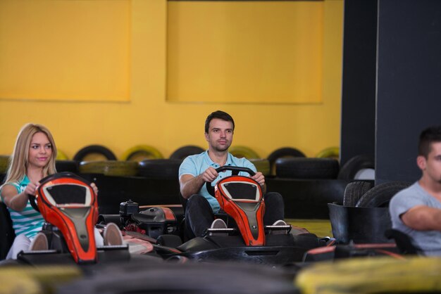 Foto grupo de personas está conduciendo coche gokart con velocidad en una pista de carreras de juegos go kart es un deporte de motor de ocio popular