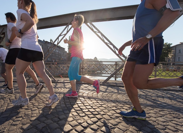 grupo de personas corriendo equipo de corredores en el entrenamiento matutino con el amanecer en el fondo