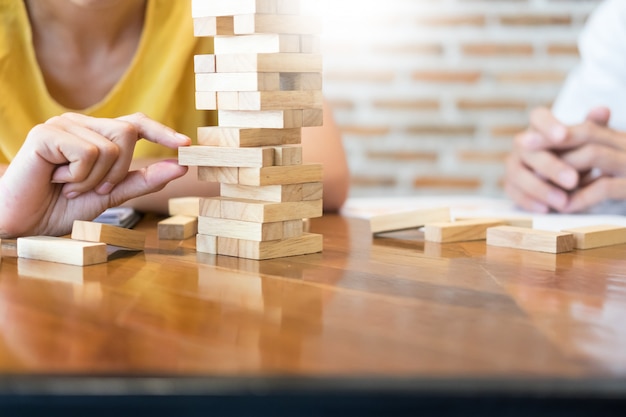 Grupo de personas creativas de negocios que construyen la torre por bloques de madera