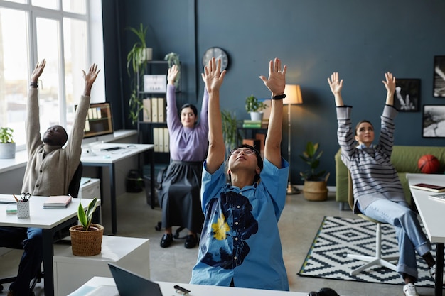 Grupo de personas disfrutando de estiramientos en la oficina