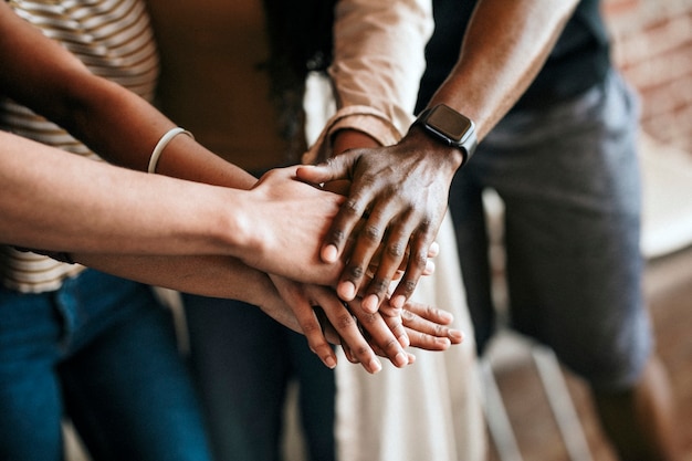 Foto grupo de personas diversas apilando las manos en el medio