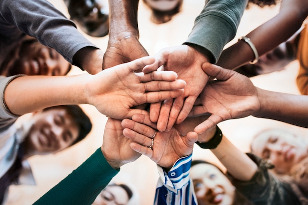 Grupo de personas diversas apilando las manos en el medio