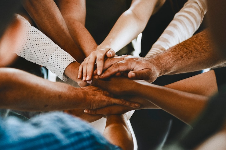 Foto grupo de personas diversas apilando las manos en el medio