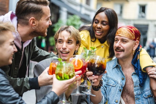 Grupo de personas diversas brindando con bebidas amigos felices celebrando y bebiendo cócteles en el restaurante concepto de inclusión social lgbt