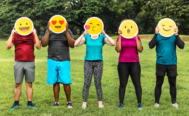 Grupo de personas diversas con emoticon.