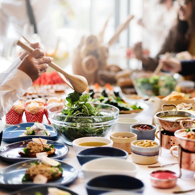 Grupo de personas diversas están almorzando juntos.