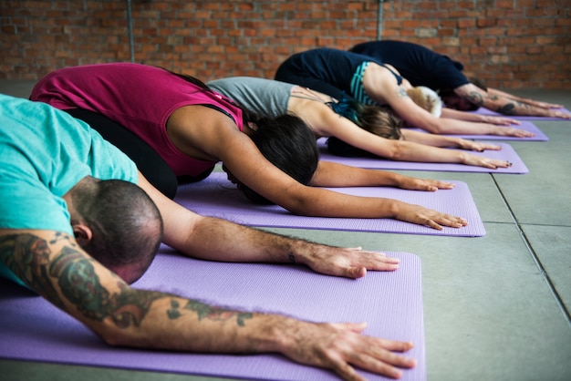 Grupo de personas diversas se están uniendo a una clase de yoga