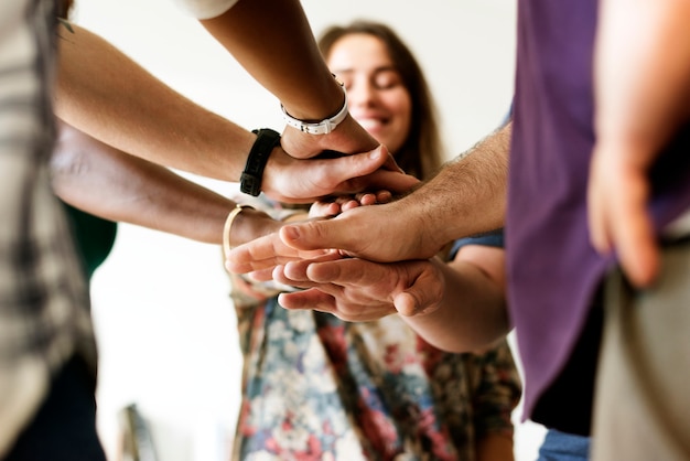 Grupo de personas diversas. Manos unidas. Trabajo en equipo.