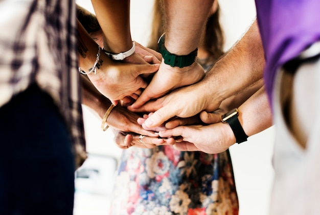 Grupo de personas diversas. Manos unidas. Trabajo en equipo.