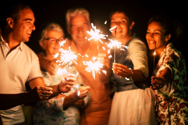 Grupo de personas se divierten celebrando junto con destellos.