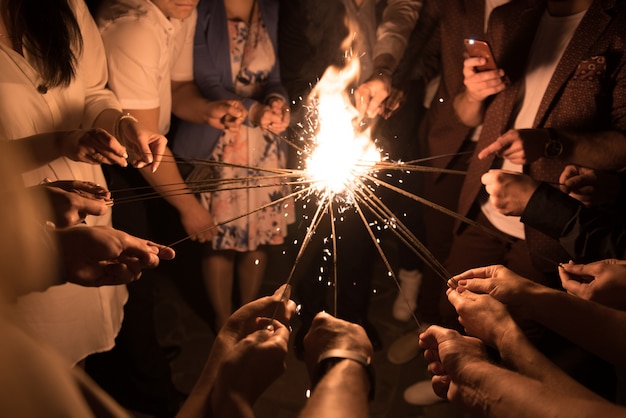 Grupo de personas encendiendo luces de Bengala juntas. Fraternidad