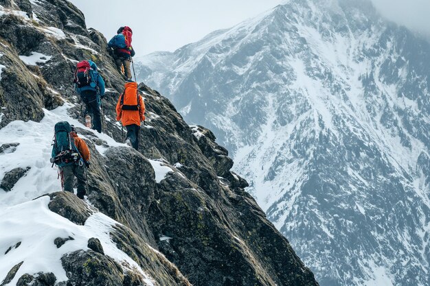 Foto grupo de personas escalando una montaña cubierta de nieve