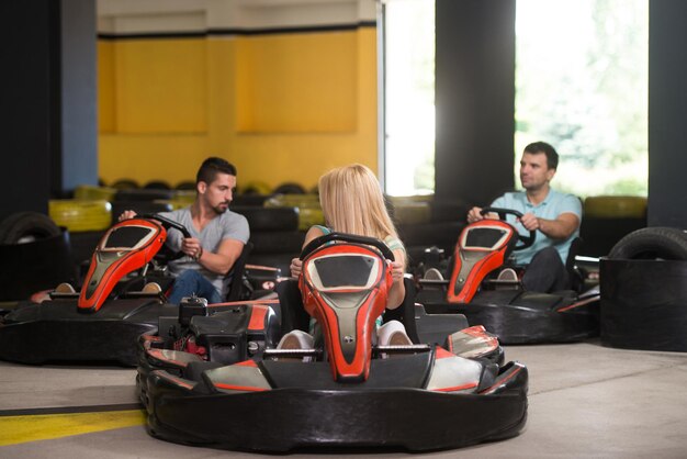 Grupo de personas está conduciendo coche GoKart con velocidad en una pista de carreras de juegos Go Kart es un deporte de motor de ocio Popular