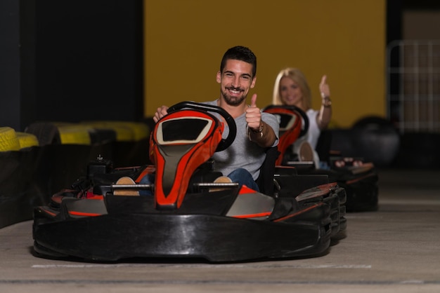 Grupo de personas está conduciendo coche GoKart con velocidad en una pista de carreras de juegos Go Kart es un deporte de motor de ocio Popular