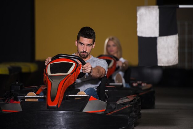 Grupo de personas está conduciendo coche GoKart con velocidad en una pista de carreras de juegos Go Kart es un deporte de motor de ocio Popular