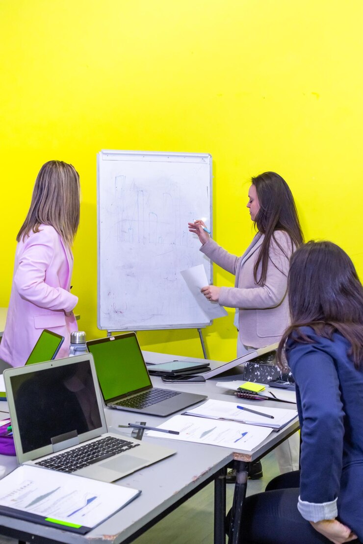 Foto un grupo de personas están sentadas alrededor de una mesa con una pizarra delante de ellas