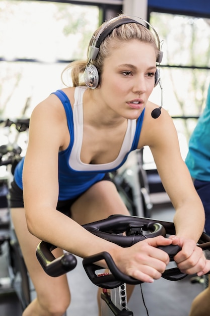 Grupo de personas en forma usando bicicleta juntos en el gimnasio