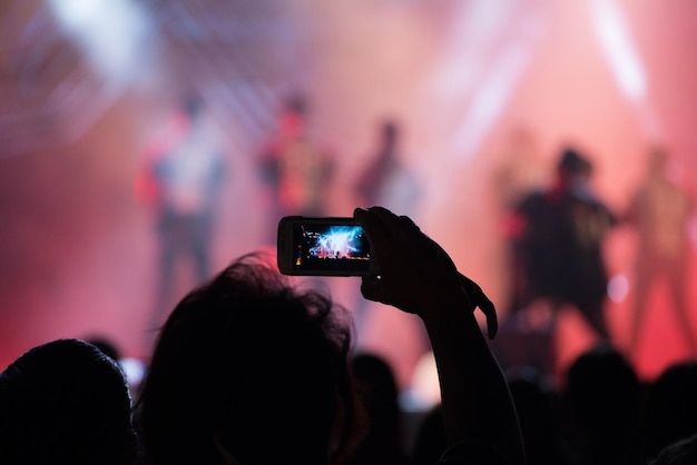 Grupo de personas fotografiando un concierto de música