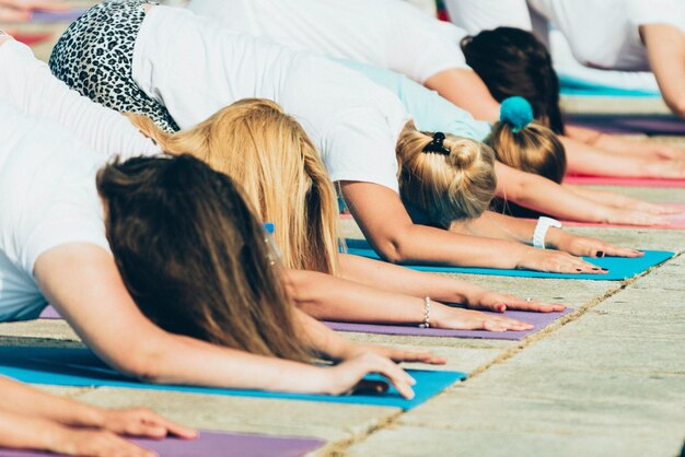 Grupo de personas haciendo pose infantil en evento de yoga al aire libre