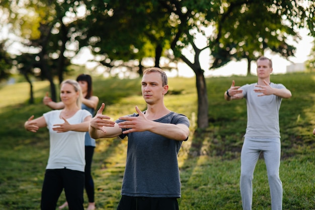 Un grupo de personas haciendo yoga en el parque.