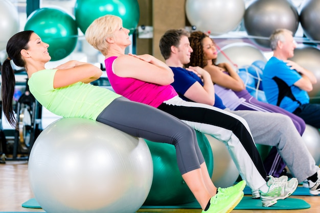 Grupo de personas jóvenes y mayores haciendo ejercicio en el gimnasio