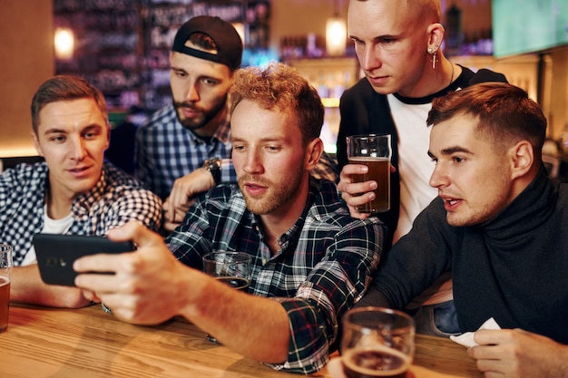 Un grupo de personas juntas en el interior del pub se divierten los fines de semana