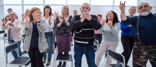 Grupo de personas maduras aplaudiendo después de reunirse