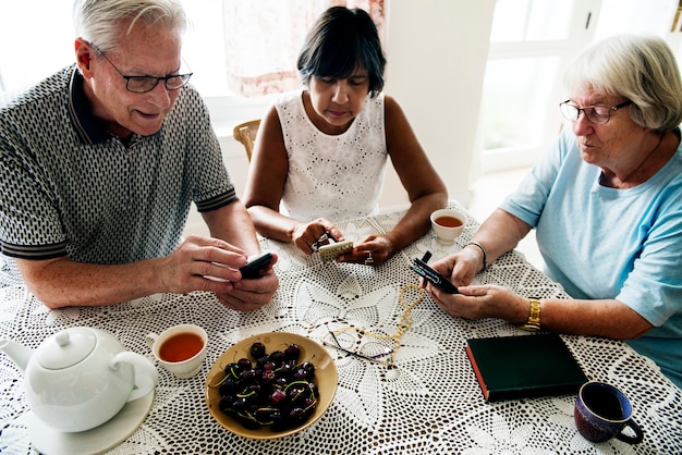 Grupo de personas mayores diversas que usan el teléfono móvil