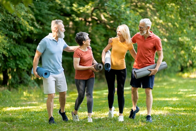 Grupo de personas mayores felices haciendo entrenamiento deportivo juntos al aire libre