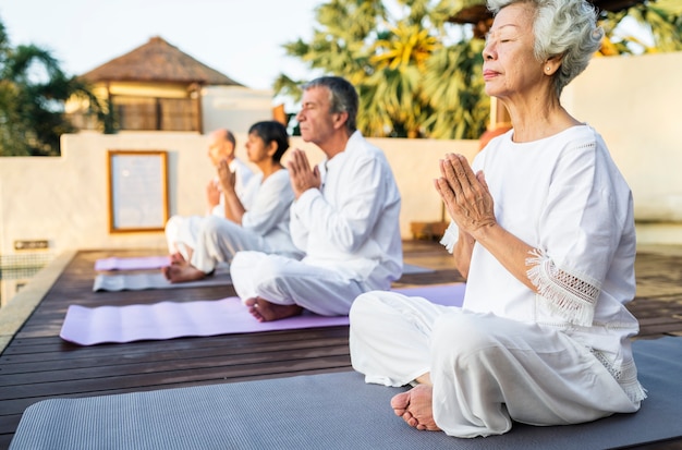 Grupo de personas mayores practicando yoga por la mañana