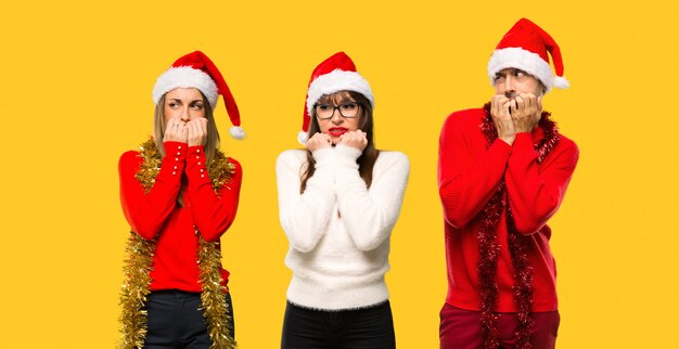 Un grupo de personas, una mujer rubia vestida para las vacaciones de navidad, está un poco nerviosa.