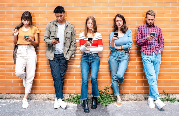 Grupo de personas multiculturales con smartphone en el patio de la universidad universitaria