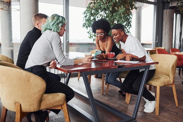 Grupo de personas multiétnicas con chica alternativa con cabello verde está trabajando juntos