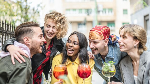 Grupo de personas multirraciales brindando bebidas en el bar de cócteles, amigos reuniéndose para divertirse, amigos de varias generaciones