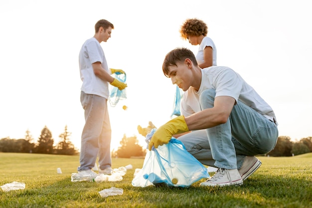 grupo de personas multirraciales con guantes y con bolsas de basura eliminan plástico y basura en el parque