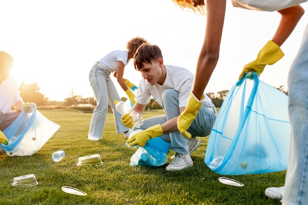 Foto grupo de personas multirraciales con guantes y con bolsas de basura eliminan plástico y basura