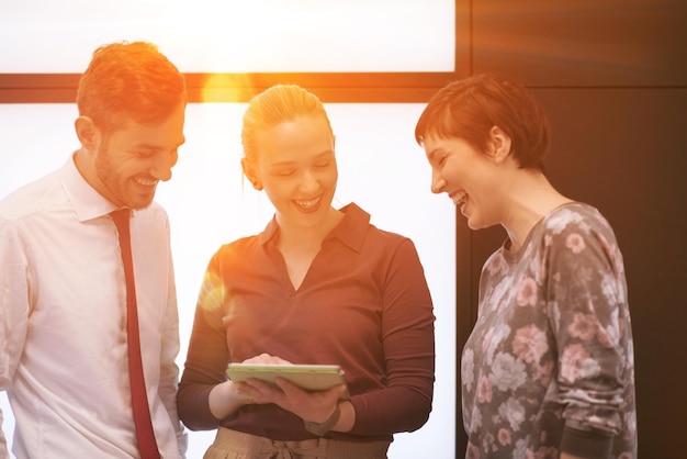 grupo de personas de negocios de inicio joven, lluvia de ideas y trabajo en la llamarada solar de la computadora de la tableta y el amanecer en segundo plano