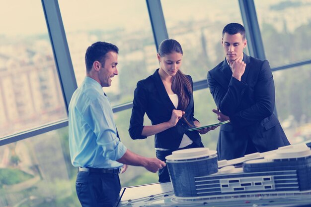 grupo de personas de negocios en reunión y presentación en una oficina moderna y luminosa con arquitecto ingeniero de construcción y trabajador que busca modelos de construcción y planes de planos